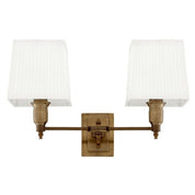 Lámpara de pared Lexington doble con acabado en latón antiguo y pantallas blancas.