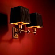 Lámpara de pared Lexington doble con acabado en latón antiguo y pantallas negras.